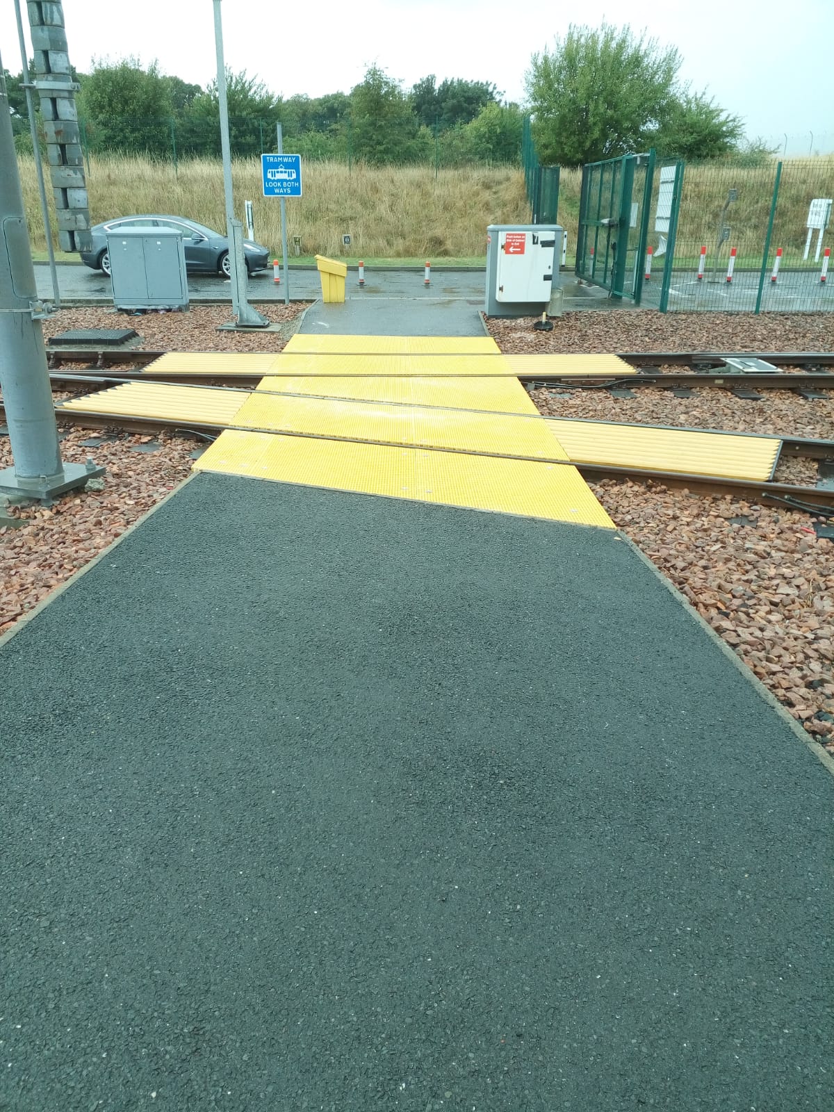 Black and yellow GRP pedestrian crossing panels installed beside the Edinburgh Trams track.