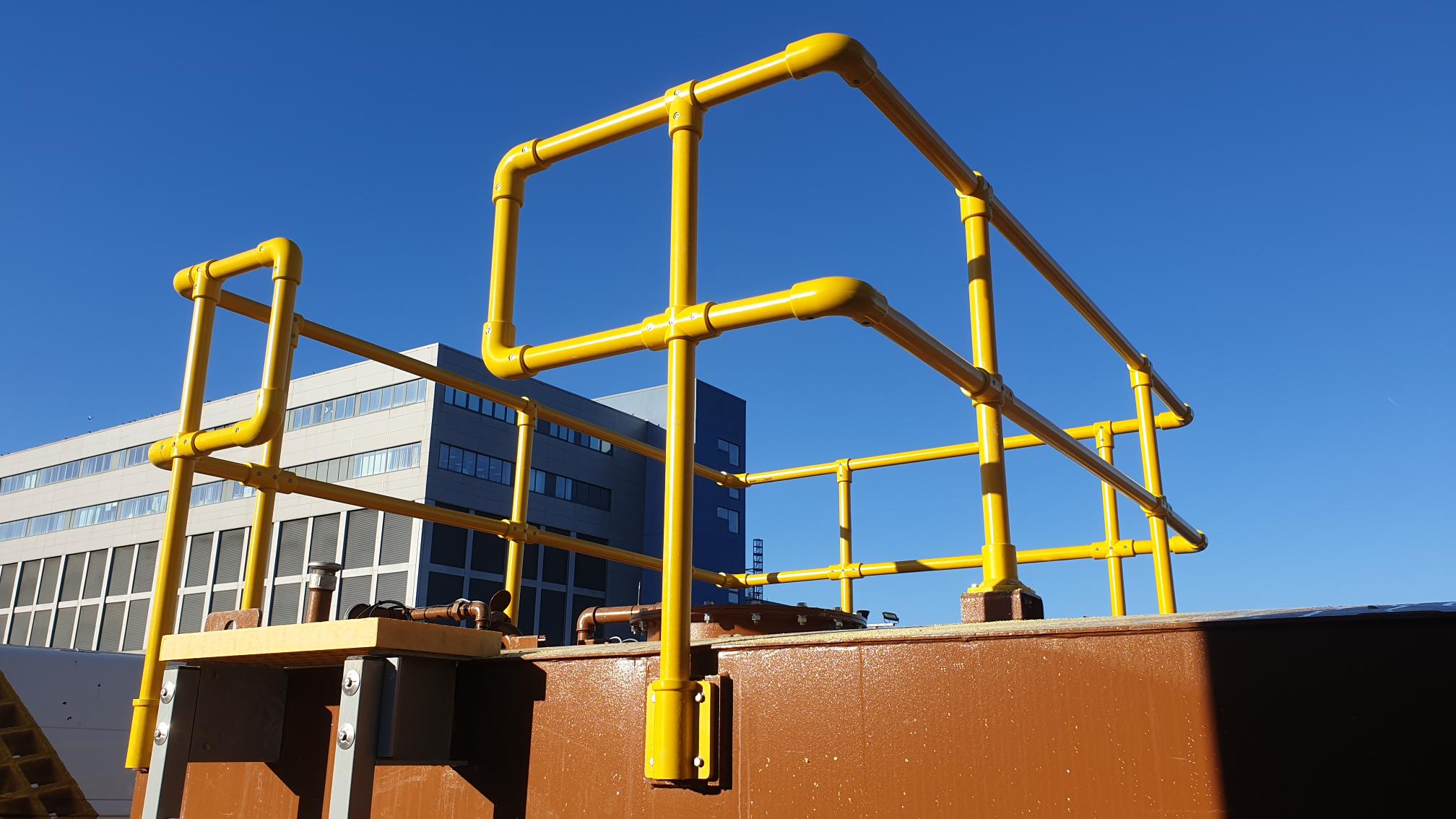 Yellow modular GRP handrail system installed around an industrial access area