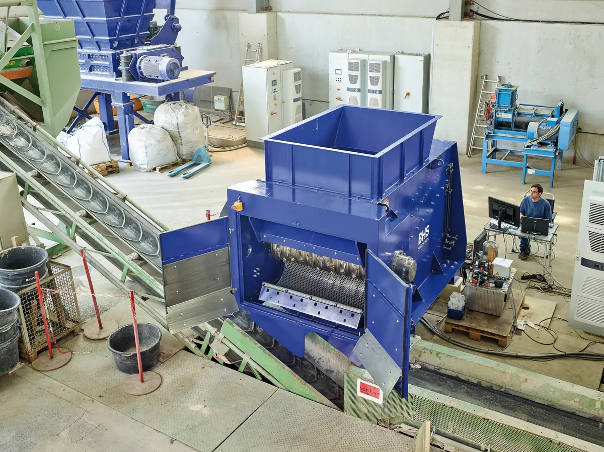 BHS industrial recycling machine processing recovered composite material in a technical facility